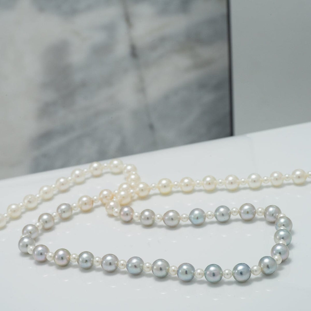 2.0-5.5 mm Intense Blue Ombre Akoya Semi-Round Pearl Strand featuring a delicate gradient of blue to white cultured pearls displayed on a white surface.