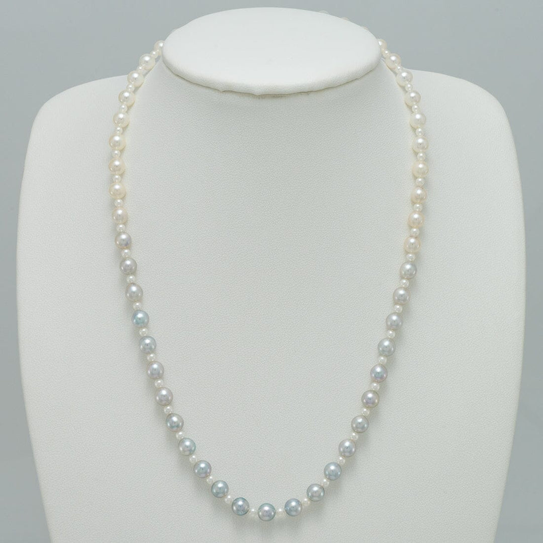 2.0-5.5 mm Intense Blue Ombre Akoya Semi-Round Pearl Strand displayed on a white necklace stand, showcasing a gradient of delicate blue to white cultured Akoya pearls.
