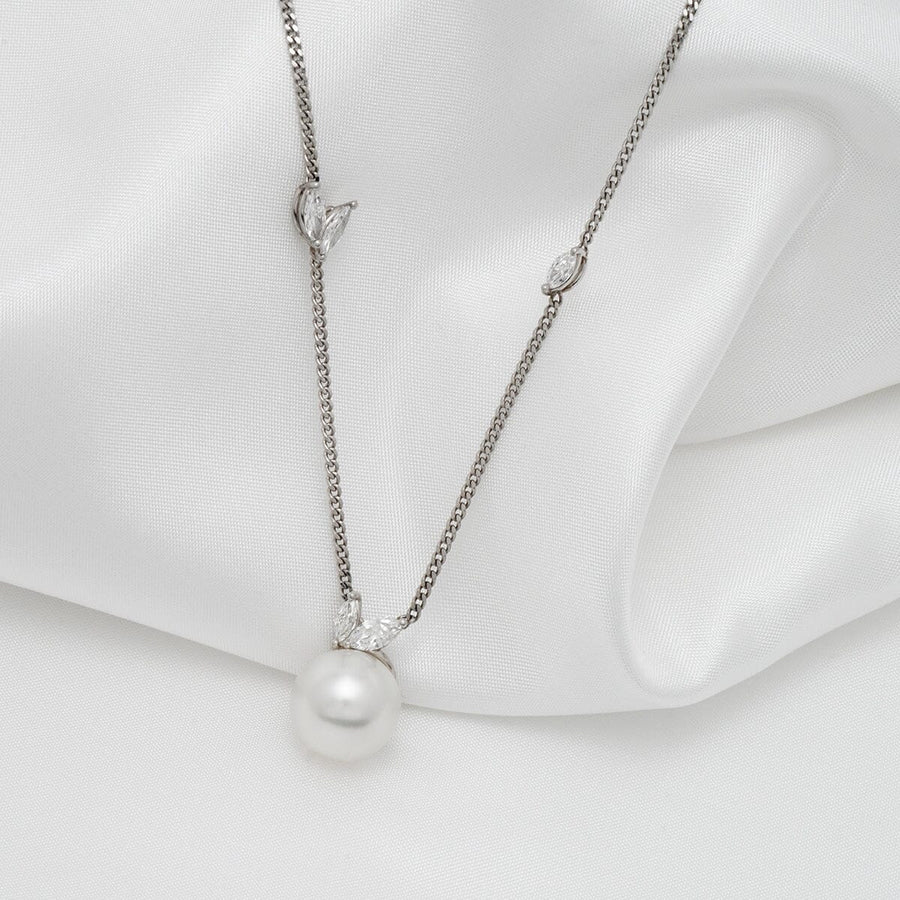 Assael Collection: 10.5-11.0 mm White South Sea Pearl and Diamond Pendant featuring a lustrous white pearl and delicate diamond accents on a fine silver chain against a soft white fabric background.