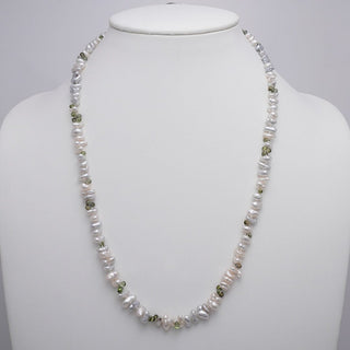 Assael Collection: 5.5–10.3 mm White South Sea Keshi Pearl and Green Sapphire Necklace featuring lustrous white pearls interspersed with small green sapphire gemstones on a white display bust.