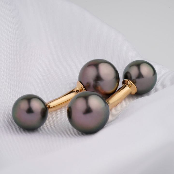 Assael Collection: 10.3–12.2 mm Tahitian Pearl Cufflinks featuring lustrous black pearls mounted on polished gold-tone metal, elegantly displayed on smooth white fabric.