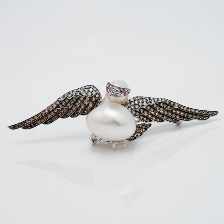 Assael Collection: 14.0 mm White South Sea Pearl, Diamond and Sapphire Brooch designed as a bird with outstretched wings set with diamonds and sapphires.