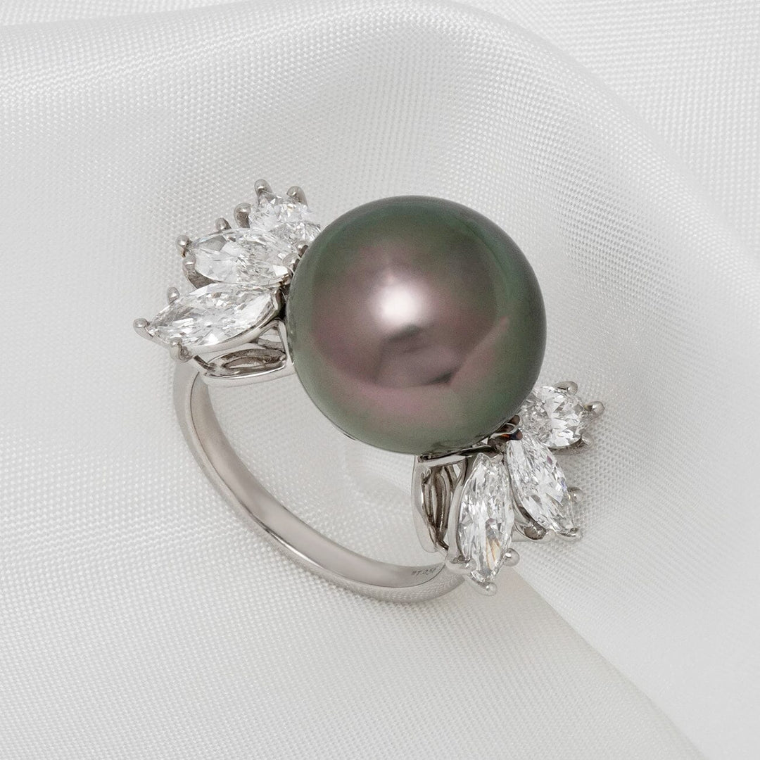 Close-up of the Assael Collection: 14.2 mm Tahitian Pearl and Diamond Ring featuring a lustrous dark Tahitian pearl set on a silver band adorned with sparkling marquise and round diamonds on a white fabric background.