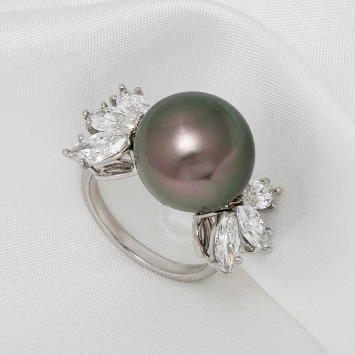 Close-up of the Assael Collection: 14.2 mm Tahitian Pearl and Diamond Ring featuring a lustrous dark Tahitian pearl set on a silver band adorned with sparkling marquise and round diamonds on a white fabric background.