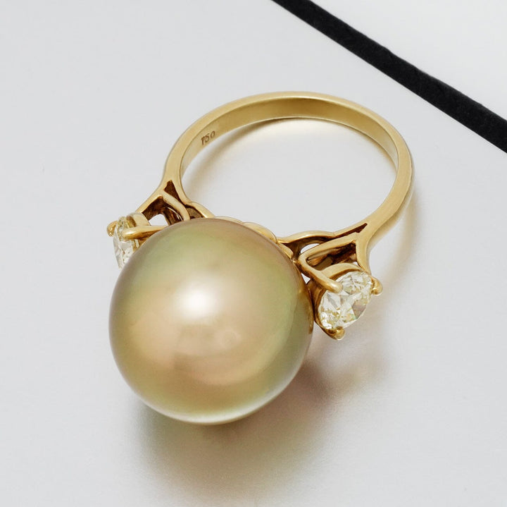 Luxurious Assael Collection: 15.4 mm Golden South Sea Pearl and Diamond Ring featuring a large golden pearl flanked by two sparkling diamonds on a polished gold band.