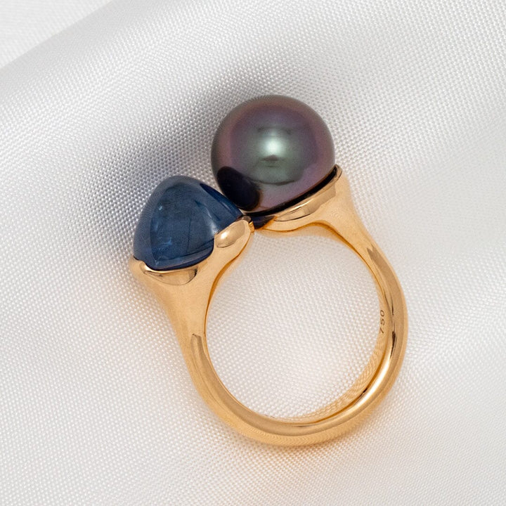Assael Collection: 10.0 mm Tahitian Pearl and Burmese Sapphire Ring featuring a polished gold band with a lustrous black Tahitian pearl and a deep blue Burmese sapphire set side by side.