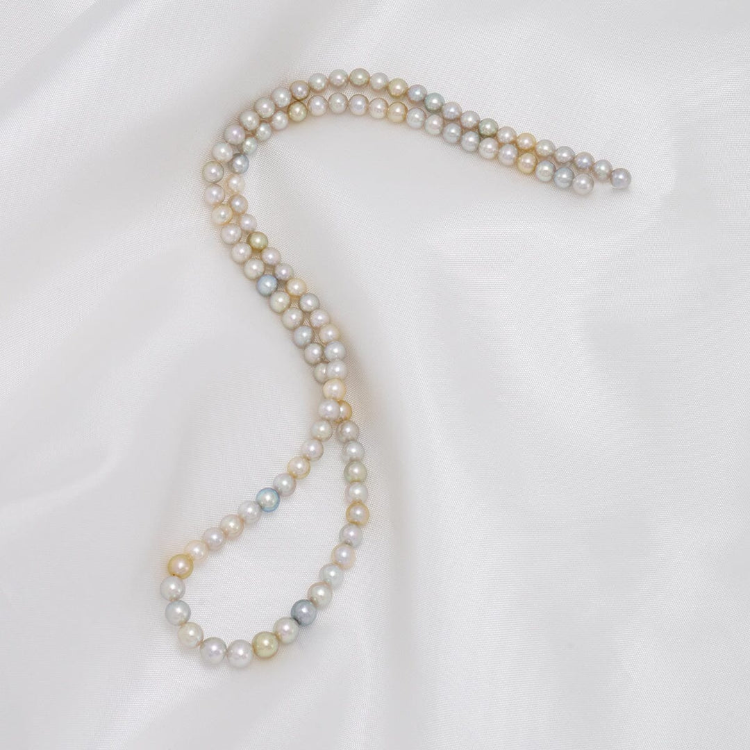 TF-26: 4-5 mm Natural Multicolor Akoya Pearl Round Strands beautifully displaying a delicate array of white, pink, yellow, and silver pearls on a soft white background.