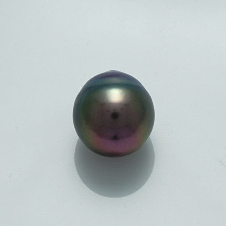Single lustrous 11.4 x 10.5 mm Fijian Drop Pearl with iridescent hues of green, purple, and black on a plain light background, showcasing its smooth surface and natural beauty.