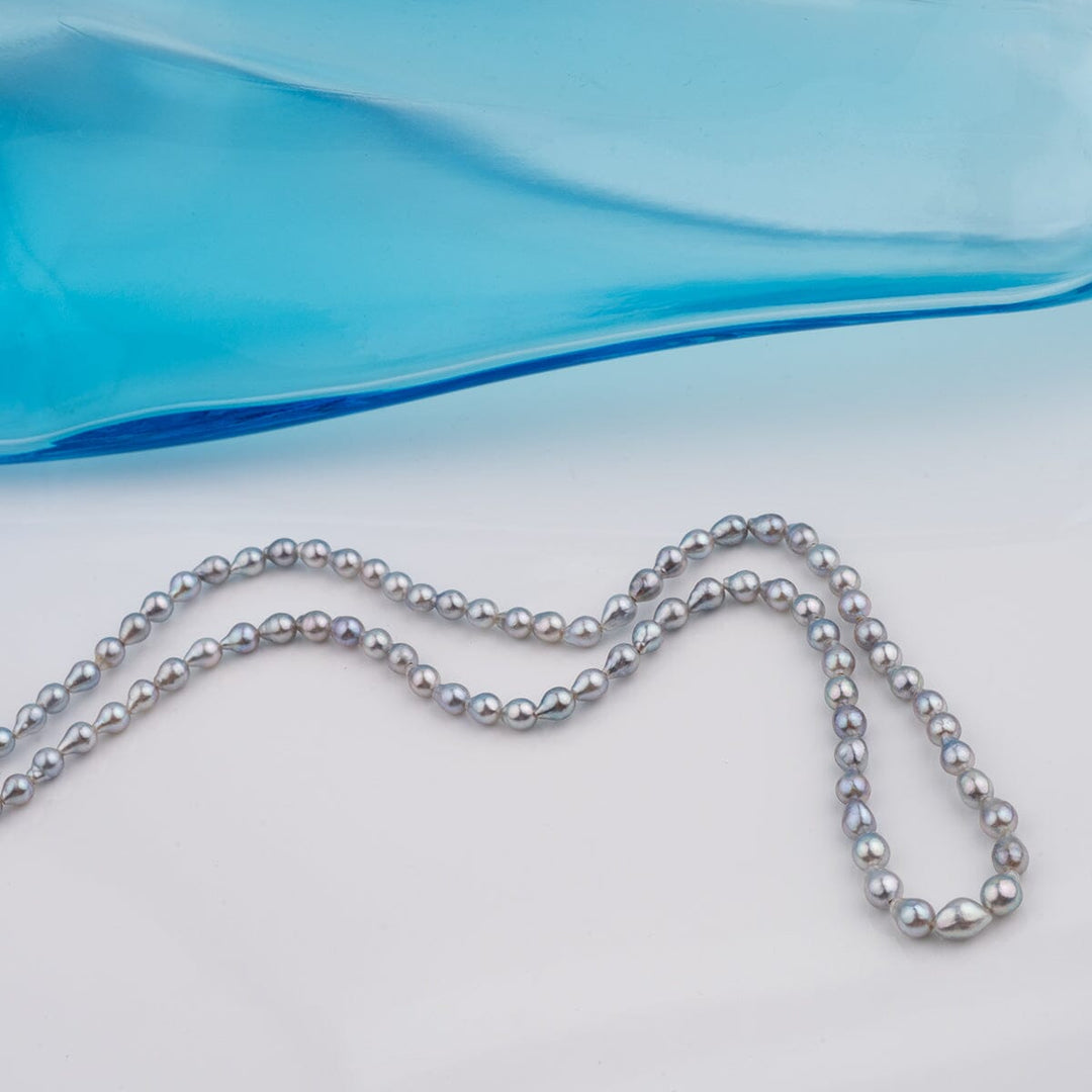 B-13: 3-4.5 mm Blue-silver Drop Akoya Strands, 16-inch Unfinished Strand featuring lustrous blue-silver akoya pearls arranged in a delicate strand against a light background.