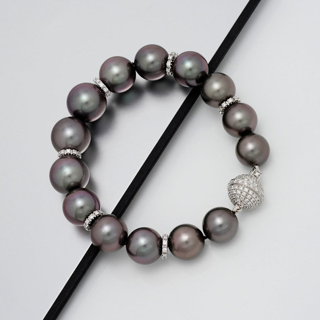 Assael Collection: 10.9–13.1 mm Tahitian Pearl and Diamond Bracelet featuring lustrous dark pearls separated by diamond-encrusted spacers and a sparkling diamond clasp.