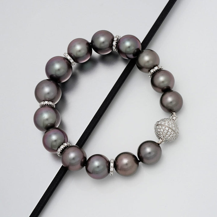Assael Collection: 10.9–13.1 mm Tahitian Pearl and Diamond Bracelet featuring lustrous dark pearls separated by diamond-encrusted spacers and a sparkling diamond clasp.