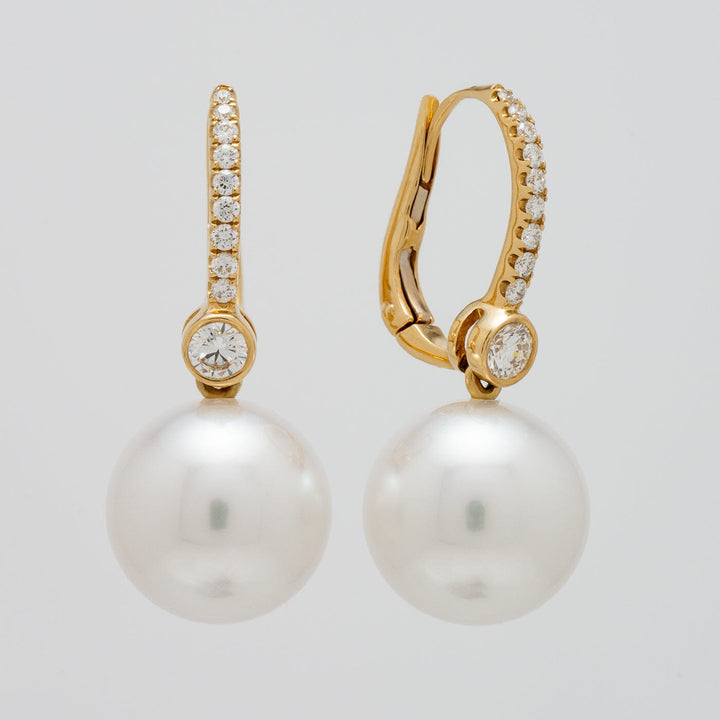 Assael Collection: 11.3 & 11.4 mm White South Sea Pearl and Diamond Earrings featuring round white pearls suspended from gold clasps adorned with sparkling diamonds.