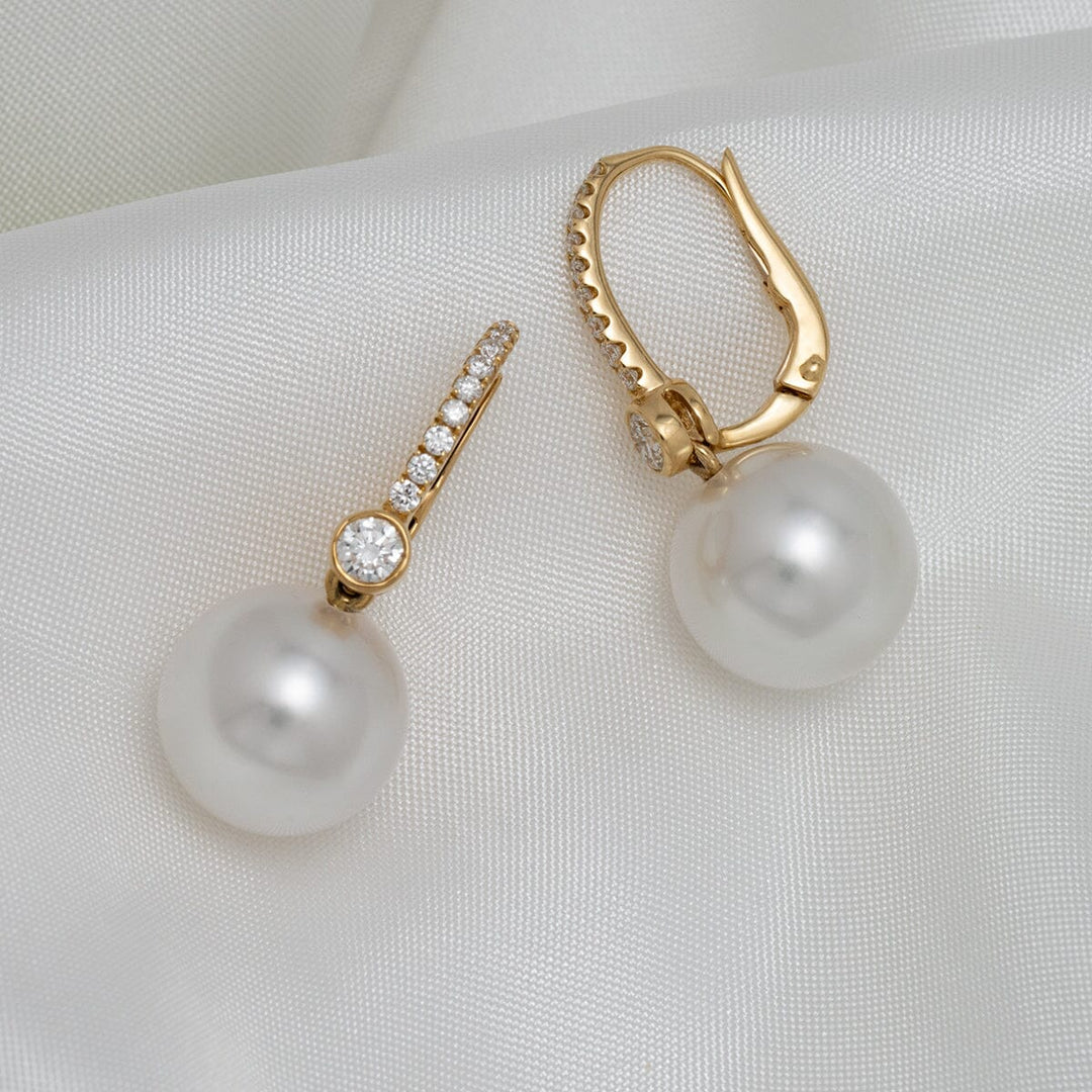 Assael Collection: 11.3 & 11.4 mm White South Sea Pearl and Diamond Earrings featuring lustrous white pearls suspended from gold lever-back settings adorned with sparkling diamonds.