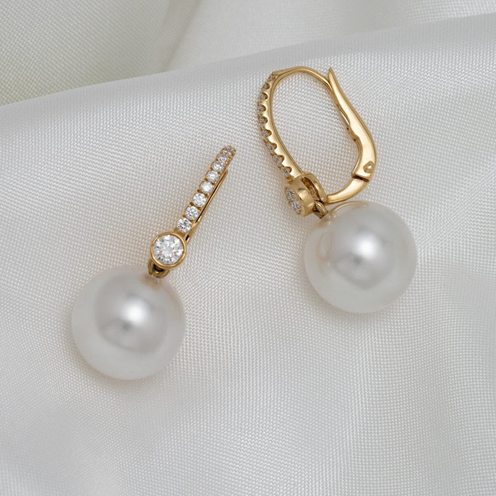 Assael Collection: 11.3 & 11.4 mm White South Sea Pearl and Diamond Earrings featuring lustrous white pearls suspended from gold lever-back settings adorned with sparkling diamonds.