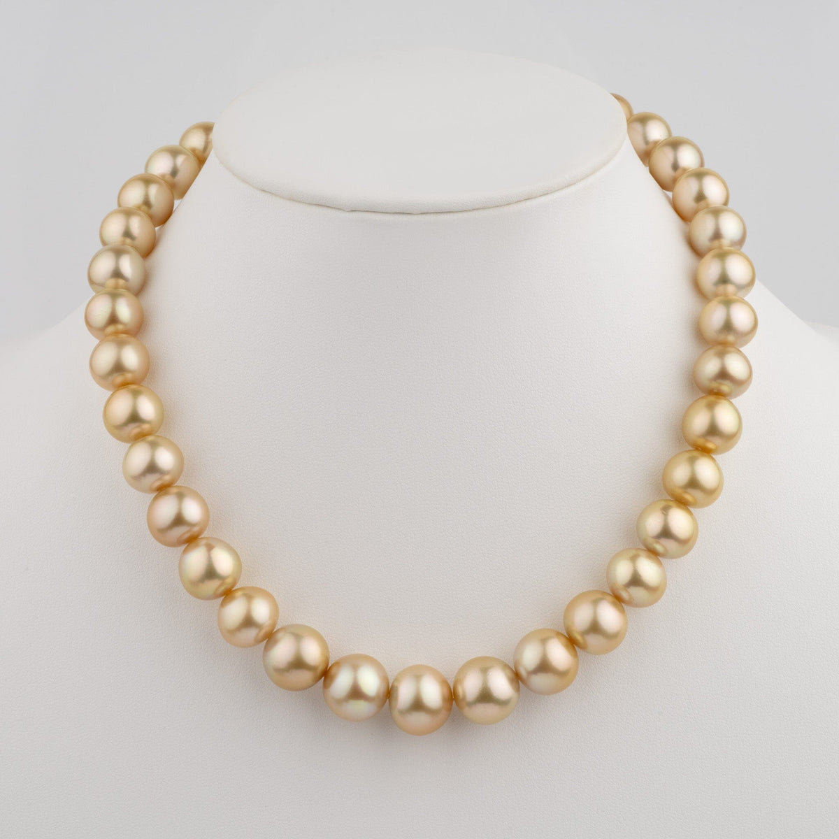 12.0–14.7 mm AA+/AAA Golden South Sea Round Pearl Necklace displayed on a white jewelry stand, showcasing lustrous golden cultured pearls in a classic strand design.