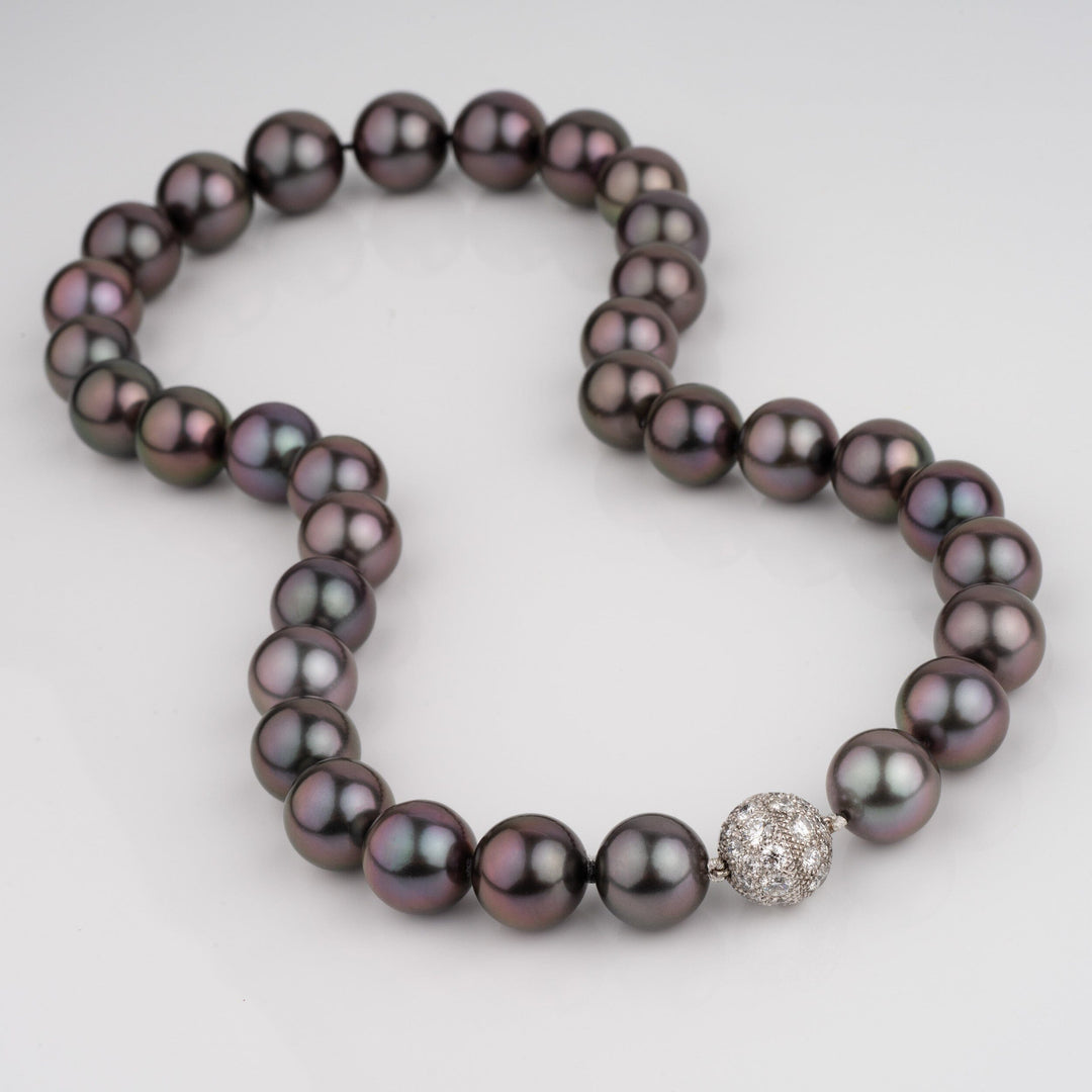 Gem quality Tahitian necklace with a dark near-black bodycolor and intense eggplant purple overtone. Round 12.0–15.0 mm pearls, natural color, finished with a 3.00 ct diamond clasp.