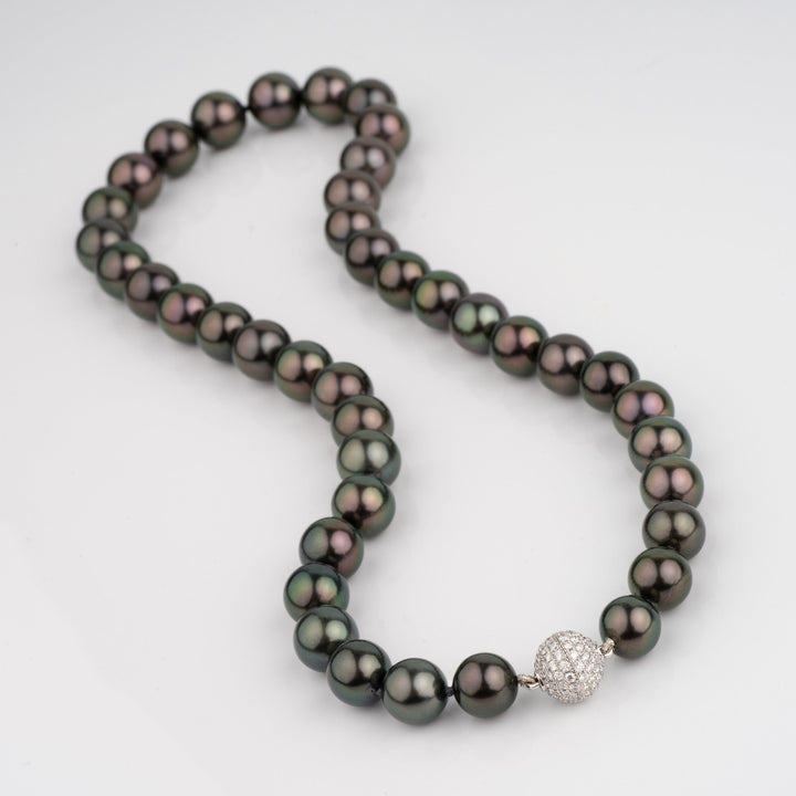 Gem Tahitian necklace with dark nearly black bodycolor and intense peacock over dark green. diamond clasp.