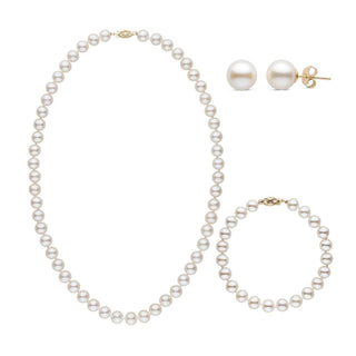 A three-piece set of white freshwater pearls including a necklace, a bracelet, and a pair of stud earrings, with each piece knotted and clasped in yellow gold.