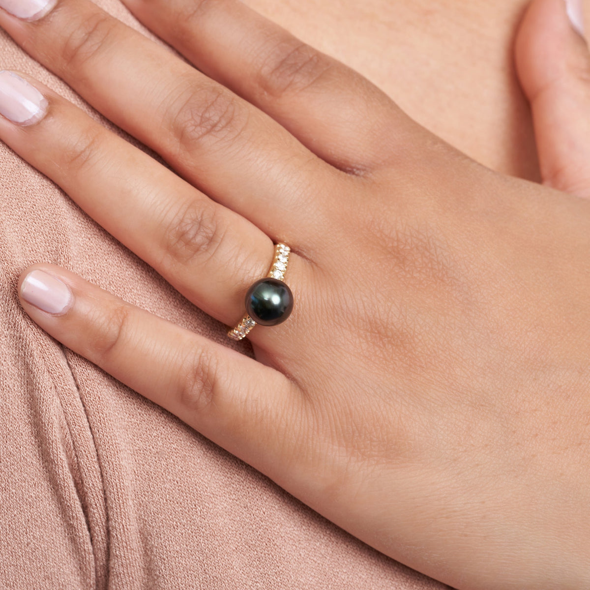 Hand wearing Decade Collection 9.0-10.0 mm Tahitian Pearl and Diamond Ring featuring a dark Tahitian pearl set on a gold band with sparkling diamonds.