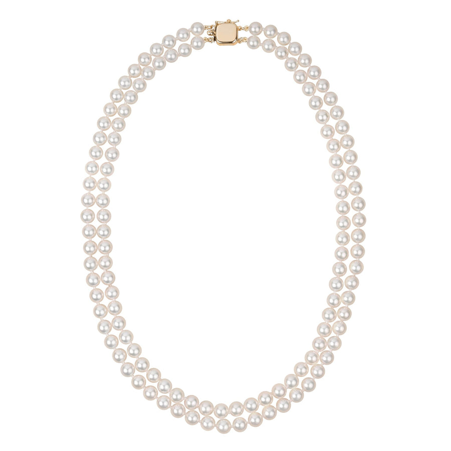 A double strand of white akoya pearls with a gold clasp, displayed against a white background.