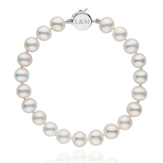 Personalized 7.5-8.0 mm AAA White Freshwater Pearl Circle Clasp Bracelet featuring lustrous white pearls and a round silver clasp engraved with initials L&M.