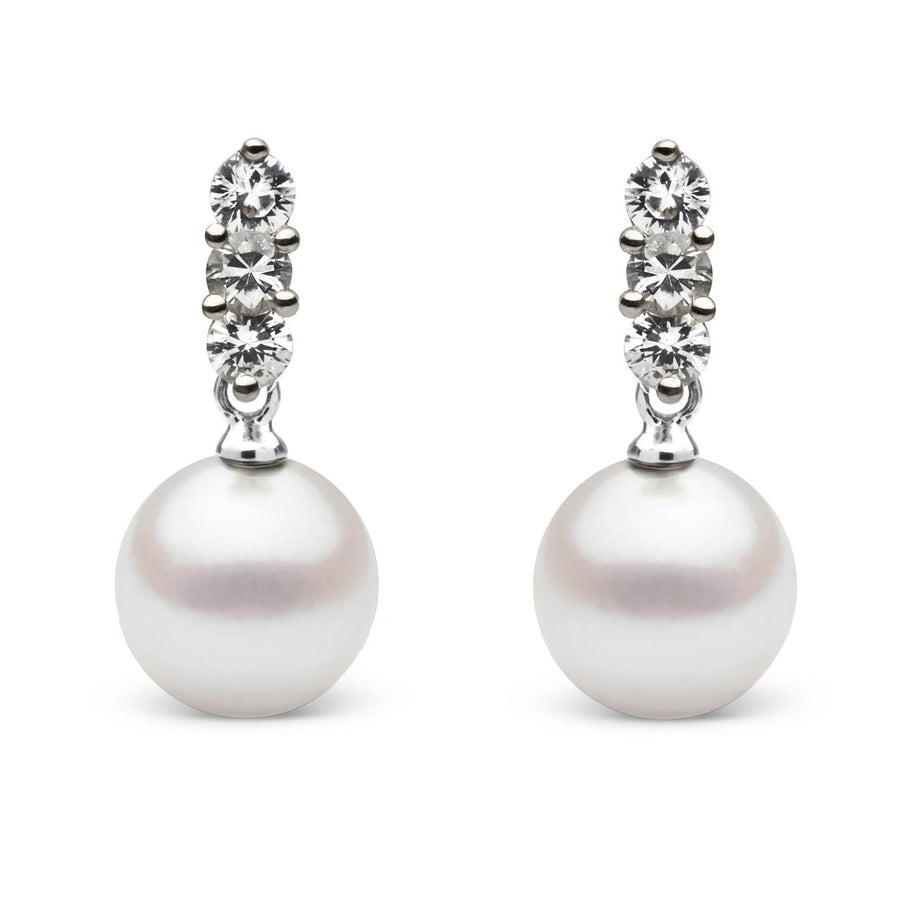 Pair of elegant Trio Collection 8.5-9.0 mm Akoya Pearl and Diamond Earrings featuring round white cultured pearls suspended from three sparkling diamonds in a classic setting.